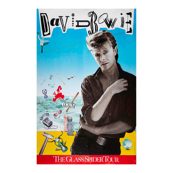 A David Bowie 'The Glass Spider Tour' poster print featuring a stylized portrait of David Bowie against a bright blue sky, with a yellow beach-like base and various floating objects and instruments.