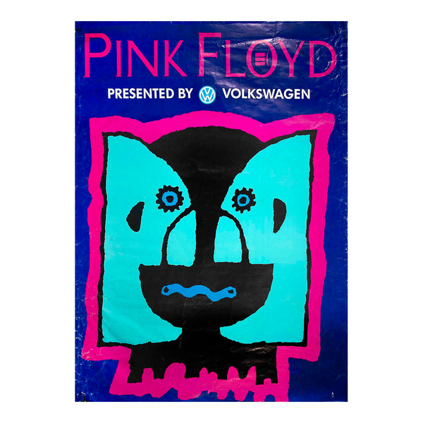 A vintage-style Pink Floyd poster with a stylized face illustration. The poster features the text 'PINK FLOYD' in pink at the top, 'PRESENTED BY VOLKSWAGEN' in white below, and a central graphic of a black cat face with turquoise ears and a bright pink border on a dark blue background.